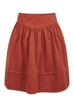 Jupe longueur genou couleur rouille avec une large ceinture et des plis décoratifs, dotée de boutons dorés sur le côté.