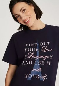 Granatowa koszulka bawełniana z krótkim rękawem, z białym i różowym napisem oraz niebieską grafiką wieży Eiffla na środku.