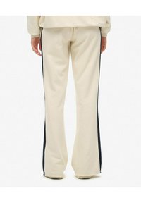 Beige uitlopende sweatpants met contrasterende zwarte zijstrepen, gemaakt van een zachte stof; heeft een comfortabele pasvorm en rechte zoom.