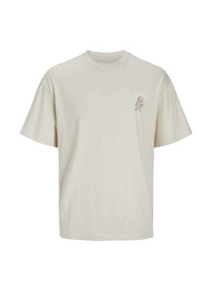 Camiseta de manga corta beige de algodón suave; presenta un pequeño estampado floral azul en el lado izquierdo del pecho; corte relajado con cuello redondo.