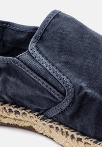 Scarpa in tela blu navy con bordi cuciti e suola in juta intrecciata; texture morbida; punta arrotondata; pannelli laterali elastici per una facile vestibilità.