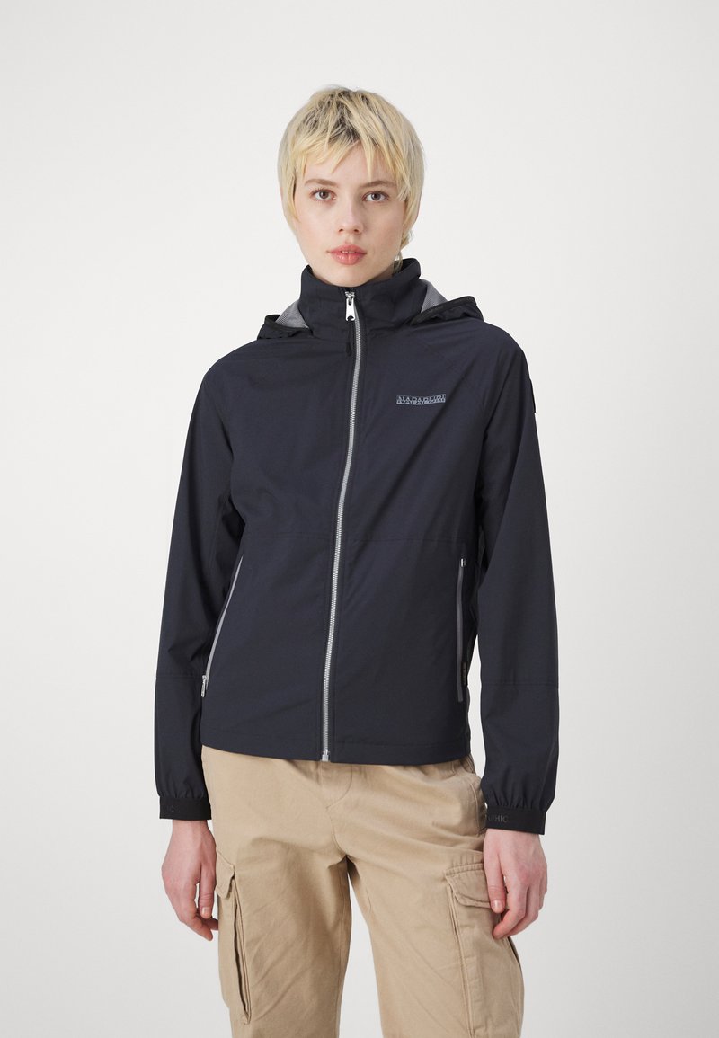 Giubbotto impermeabile blu navy con colletto alto, zip frontale, polsini elasticizzati e fodera grigia. Presenta un logo sul petto e due tasche laterali.