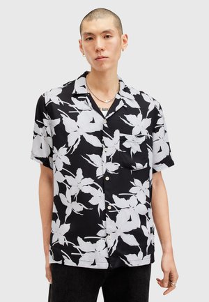 Kortsleevet svart skjorte med et stort hvitt blomstermønster, lett stoff, notched krage, en brystlomme og lyse knapper.