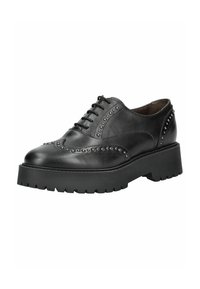Chaussure brogue en cuir noir avec clous argentés, semelle épaisse à crampons et lacets à l'avant, conçue pour un usage décontracté ou formel.