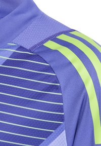 Paarse sporttrui met groene strepen, gemaakt van geavanceerde stof, met gaassecties en een geometrisch patroon. Fitted ontwerp met een atletische snit.
