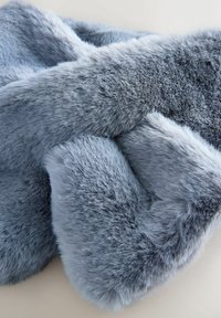 Soft light blue faux fur fabric with dense, plush texture, gently folded against a pale, neutral background.