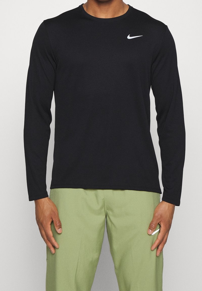 Schwarzes Nike-Shirt mit langen Ärmeln und rundem Ausschnitt, aus glattem Stoff, mit einem weißen Logo auf der linken Brust.