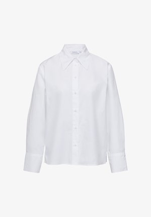 Biała koszula z długim rękawem, zapinana na guziki, z kołnierzykiem o szerokim kroju, wykonana z gładkiego materiału. Charakteryzuje się luźnym fasonem i lekko obniżonymi ramionami.