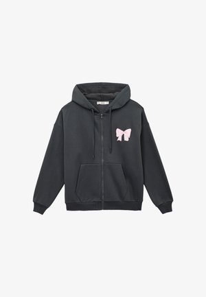 Dunkelgrauer Reißverschluss-Hoodie mit einem pinken Schleifen-Emblem auf der linken Brust, ausgestattet mit einer Fronttasche und gerippten Bündchen und Saum. Weicher Stoff.