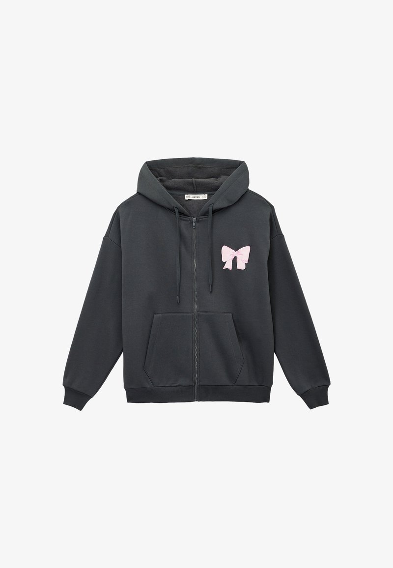 Dunkelgrauer Reißverschluss-Hoodie mit einem pinken Schleifen-Emblem auf der linken Brust, ausgestattet mit einer Fronttasche und gerippten Bündchen und Saum. Weicher Stoff.