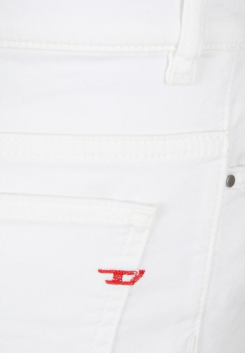 Tessuto denim bianco con una texture liscia. Presenta un logo ricamato rosso sulla tasca posteriore, cuciture bianche e dettagli di cucitura aggiuntivi.