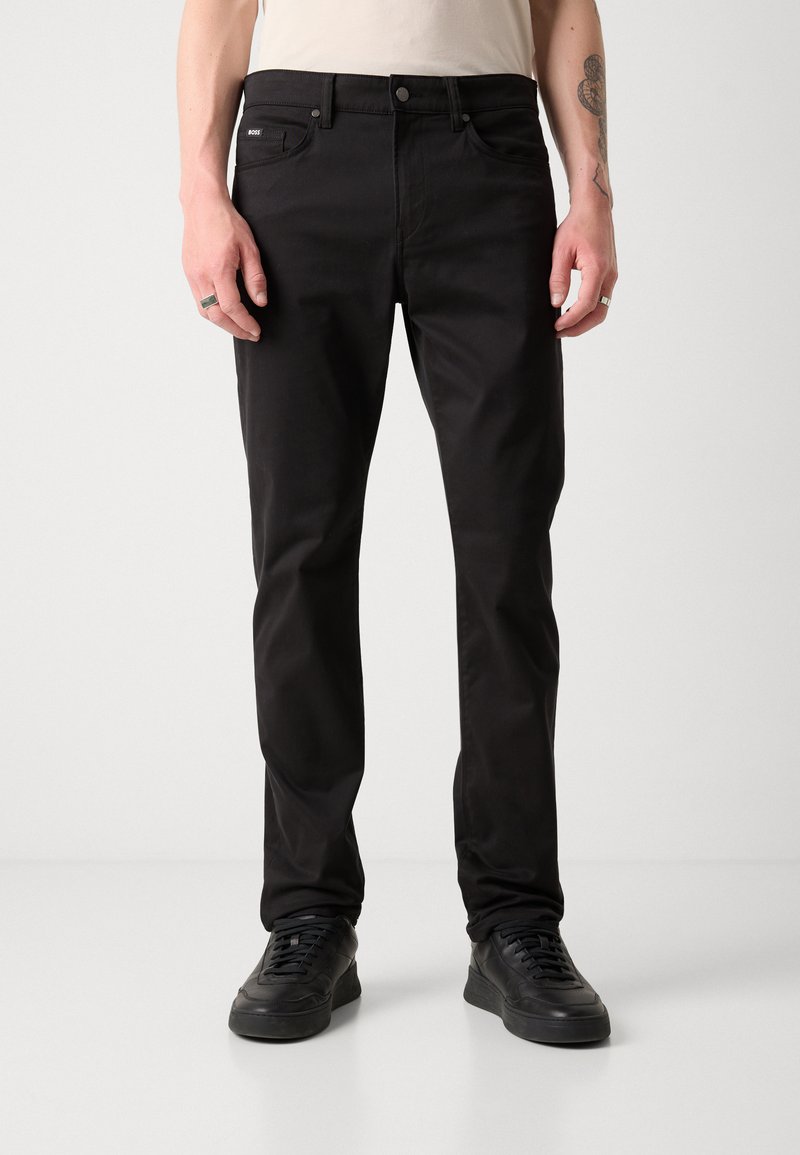 Svarta bomullstrousers med smal passform, utrustade med framfickor, knappstängning och diskret märkning på midjebandet.
