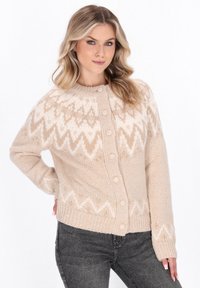 Cardigan bej tricotat, cu un finisaj texturat, prezentând un model în zigzag în nuanțe mai deschise, guler rotund și închidere cu nasturi în față.