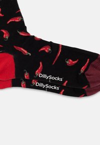 Calzini neri con motivo di peperoncini rossi; dettagli rossi sulla punta e sul tallone; logo "DillySocks" bianco vicino all'orlo.