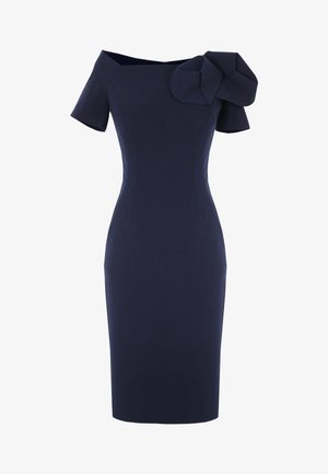 Granatowa, dopasowana sukienka do kolan z krótkimi rękawami i dużą asymetryczną kokardą na lewym ramieniu.