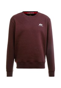 Mørkebrun crewneck sweatshirt med lange ærmer, ribstrikkede manchetter og kant samt et lille hvidt Alpha Industries-logo på brystet.