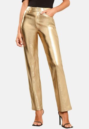 Goldene metallische gerade Beine-Hosen mit hohem Bund, seitlichen Taschen und einer glänzenden, strukturierten Oberfläche. Getragen mit schwarzen Riemchen-Heels.