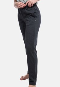 Pantaloni della tuta grigio carbone realizzati in un tessuto morbido ed elastico, con un fit rilassato, tasche laterali e una comoda fascia elastica in vita.