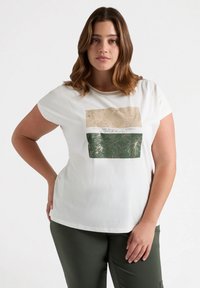 Camiseta blanca con cuello redondo que presenta tres paneles gráficos rectangulares: uno beige con hojas, texto, y un diseño de follaje verde debajo.