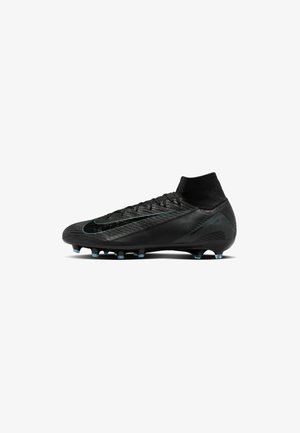 Black soccer cleat with textured upper, sock-like collar, and a distinct green accent. Features conical studs for traction on grass.