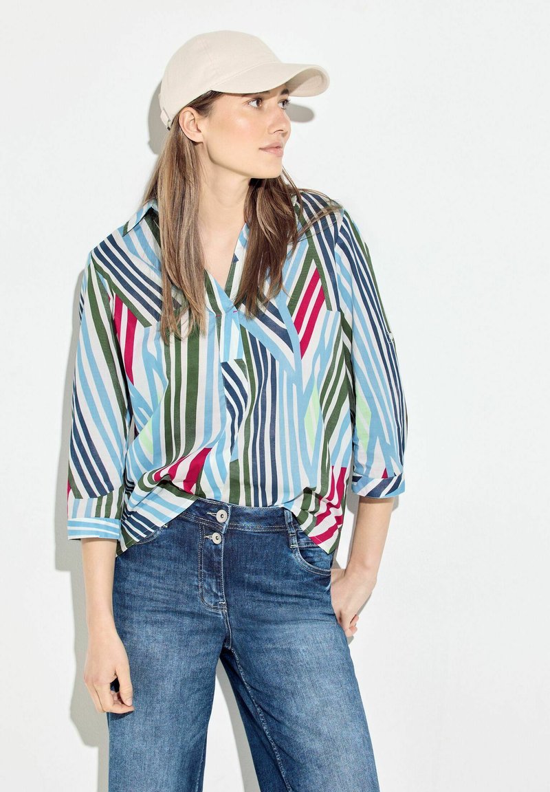 Multicolored striped shirt with a collar and three-quarter sleeves, made of lightweight fabric; paired with dark blue denim jeans.