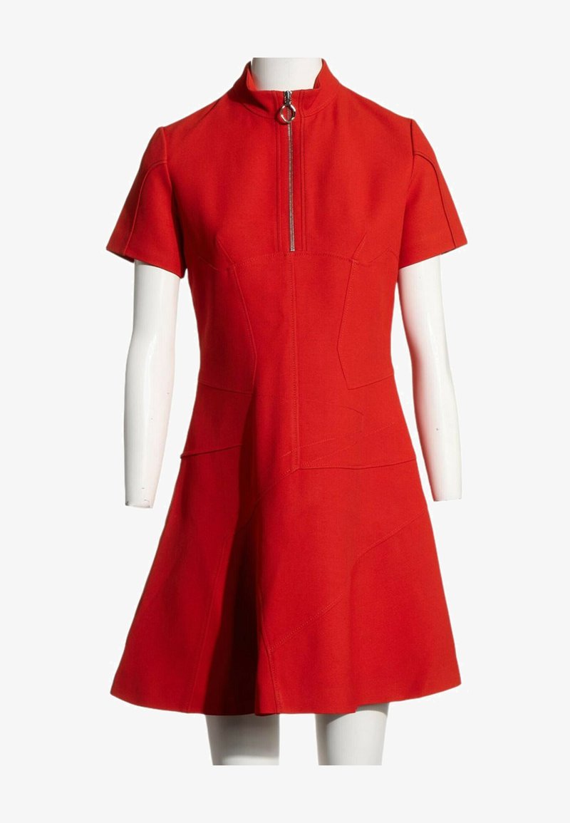 Robe rouge manches courtes en ligne A avec col montant et fermeture éclair devant avec tirette circulaire, présentée sur un mannequin blanc.
