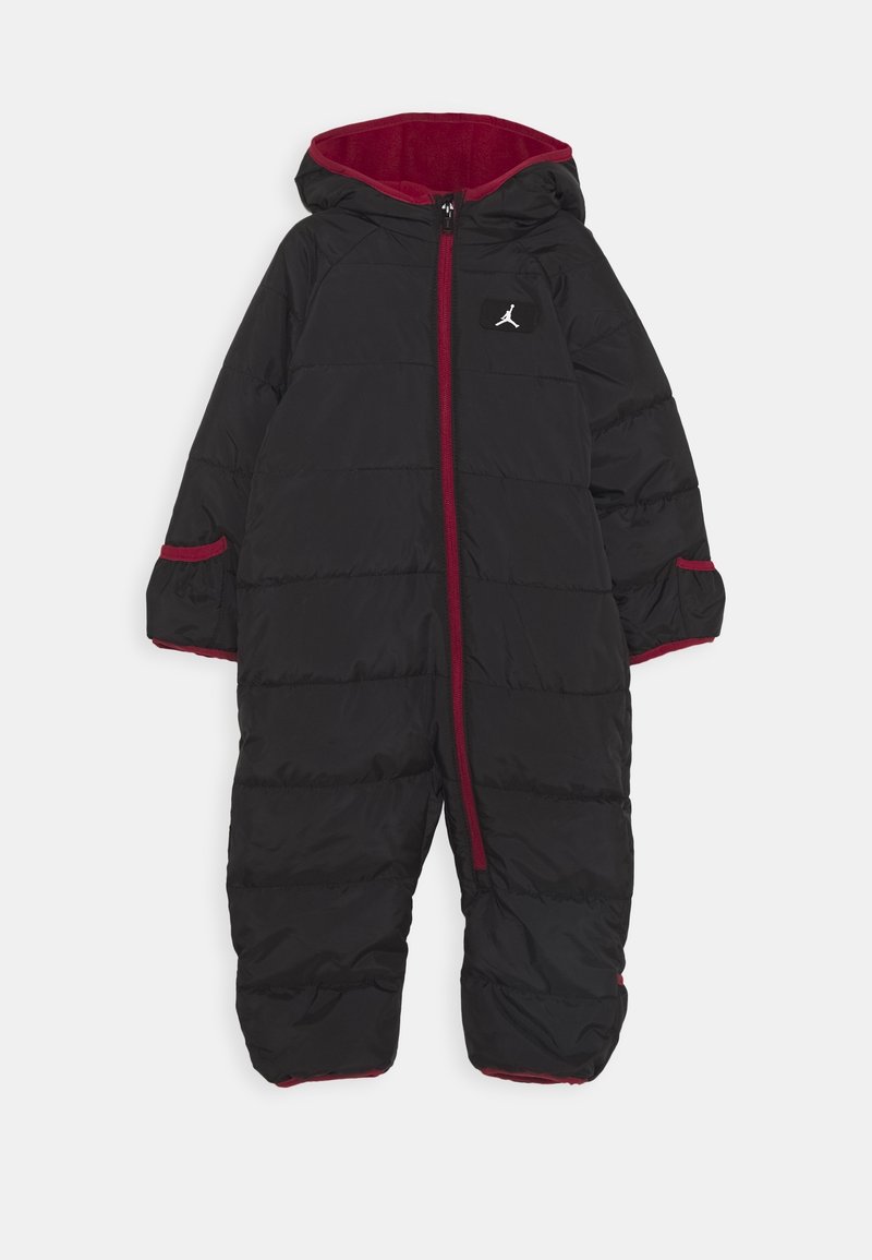 Combinaison de neige noire à capuche avec garniture rouge, fermeture éclair à l'avant, manches longues et petit logo sur la poitrine.