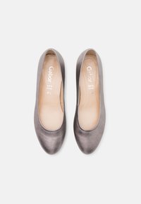 Ballerines Gabor grises avec une texture lisse, un bout arrondi et une semelle intérieure rembourrée. Marque visible sur la semelle intérieure. Design simple et élégant.