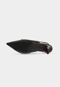 Chaussure slingback femme à bout pointu, semelle noire, talon stiletto fin et tige en cuir verni marron foncé.
