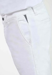 Witte denim broek met een slim fit, voorzien van zijzakken, een ritsluiting aan de voorkant en subtiele stikdetails langs de tailleband.