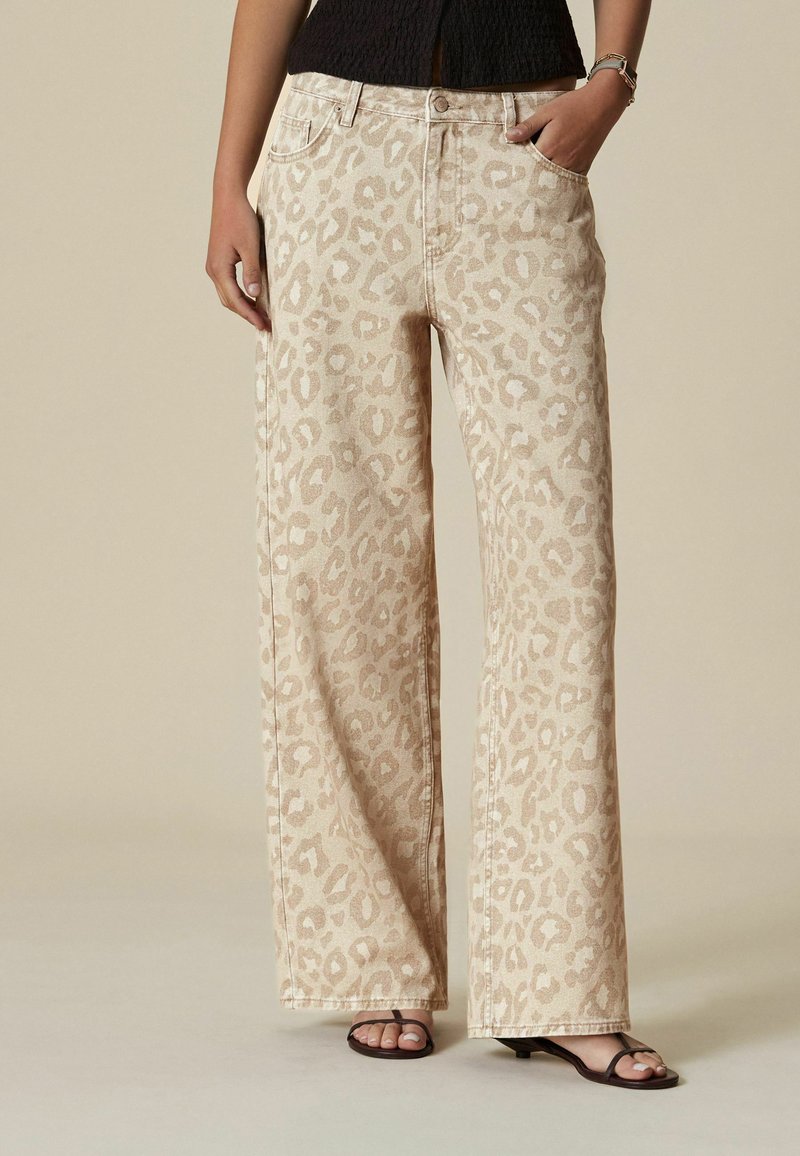 Breda, beiga denimjeans med ett leopardmönster. Har framfickor och knäppning. Mjuk textur och neutral färg.