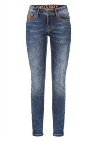 Schmale blaue Jeans mit einem verblassten Waschlook, orangefarbenem Markenlabel an der Taille und kontrastierenden Nähten an Taschen und Nähten.