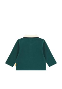 Green long-sleeved shirt with a cream-colored collar, textured fabric, and side label in yellow. Simple, classic design.