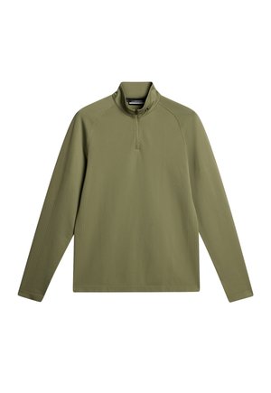 Olivengrøn langærmet pullover med halv-lynlås krave, ribbet tekstur og skrå syninger på forsiden. Fremstillet af blødt, fleksibelt stof.