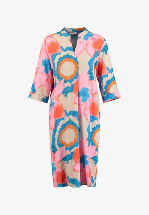 Lange beige jurk met driekwartmouwen, voorzien van grote abstracte bloemenpatronen in felroze, blauw en oranje, met een halslijn zonder kraag.