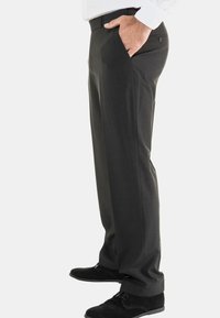 Grijze dresspants met een gladde textuur, rechte pasvorm, zijzakken en een knoopaccent. Draagt met zwarte schoenen.