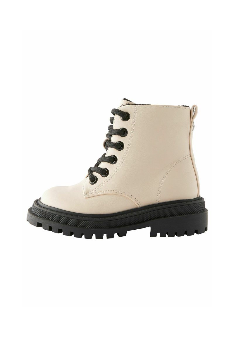Beige leren enkelboot met zwarte veters, chunky zwarte zool en een zijkantrits. Heeft een ronde neus en gestructureerde details op de zool.
