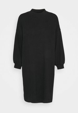 Robe pull noire à manches longues avec un col montant et des poignets côtelés, présentée sur un fond clair uni.