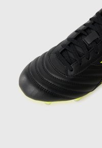 Black leather soccer cleat with black laces and neon yellow studs on a white background, showing front and side details.