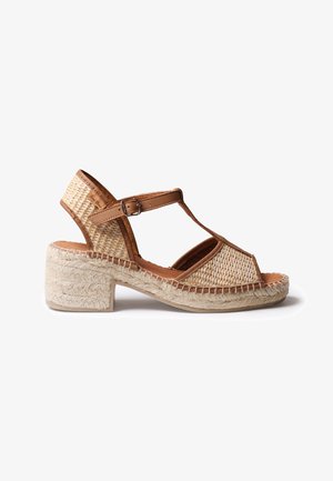 Women’s tan woven wedge sandal with ankle strap and buckle, open toe, and braided jute platform heel.