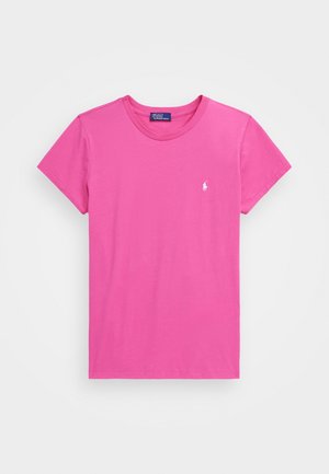 Jasnoróżowy T-shirt z krótkim rękawem i okrągłym dekoltem, z małym białym haftowanym logo na lewej piersi oraz metką Polo Ralph Lauren wewnątrz kołnierza.