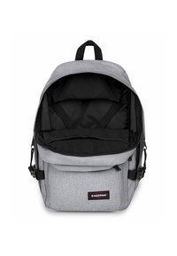 Zaino in tessuto grigio con interno nero, dotato di un compartimento principale con zip, tasca frontale e spallacci regolabili. Etichetta del logo sulla parte anteriore.