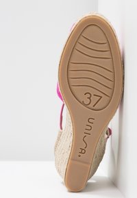 Semelle d'une chaussure compensée tissée beige avec des brides roses, taille 37, affichant le nom de la marque "Unisa" sur la semelle en caoutchouc.