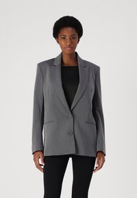 Gray tailored blazer with notch lapels, two buttons, and front pockets. Made from textured fabric, features clean lines and structured shape.