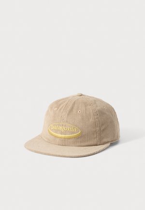 Casquette de baseball beige en velours côtelé avec logo ovale jaune brodé et texte "patagonia" sur le devant, présentée sur fond blanc.