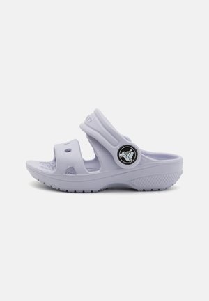 Purple rubber sandal featuring a molded design, two wide straps, ventilation holes, and a circular black logo accent.