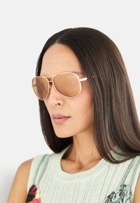 Aviator-solbriller med en tynn ramme i rosé gull metall og brune gradientlinser. Funksjoner inkluderer en dobbel brodesign og speilbelagt finish.