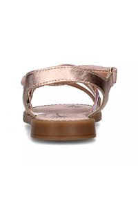 Sandal in oro rosa metallizzato con cinturini incrociati, suola piatta marrone e interno con motivo floreale. Design aperto sul retro per una facile vestibilità.