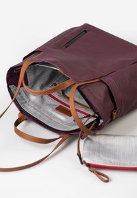 Zaino bordeaux con cinghie in pelle beige. Presenta un interno a scacchi e una tasca con zip rossa. Include una pochette staccabile coordinata.