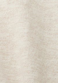 Tissu en tricot beige avec une surface douce et légèrement texturée présentant un subtil mélange de fibres claires et plus foncées. Aucun motif ou design distinct.